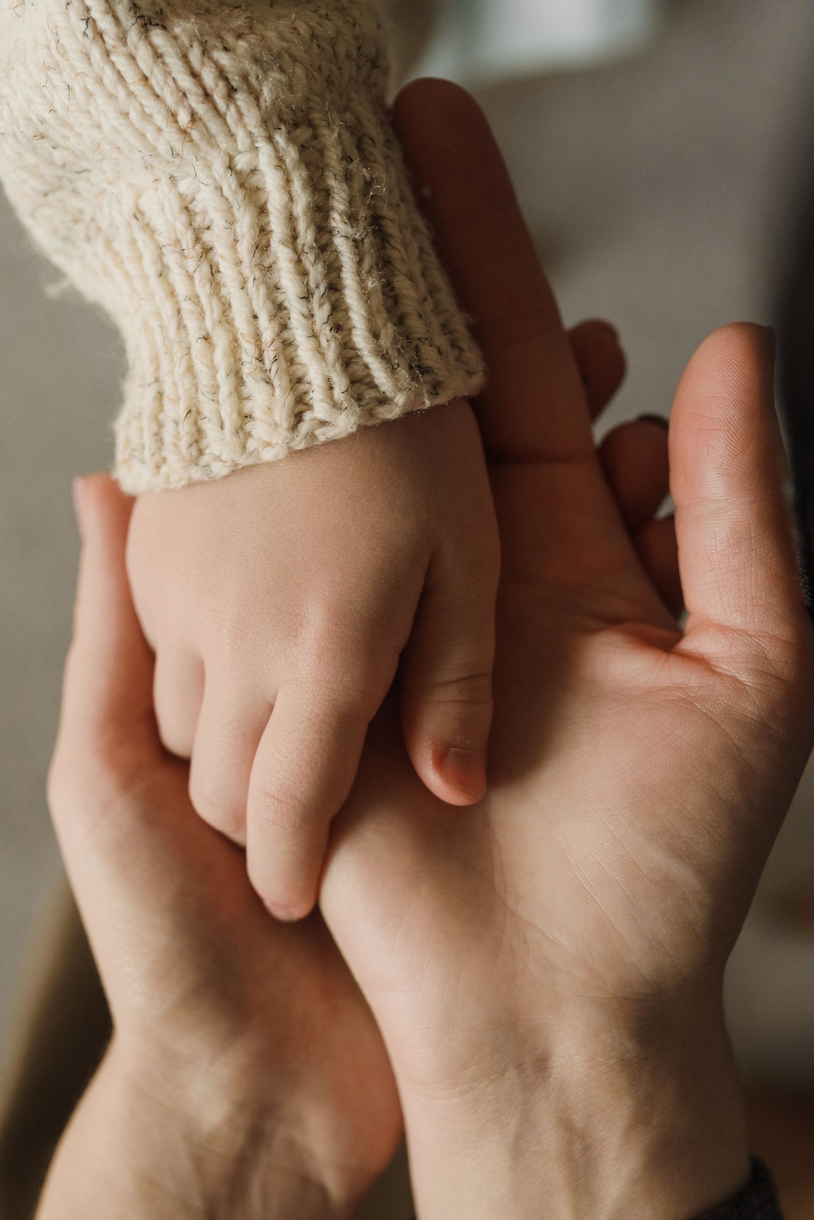 Eine Kinderhand liegt in der Hand einer erwachsenen Person